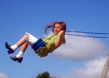 Girl swinging high in a swing
